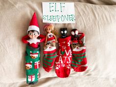 three elfs are laying next to each other on a bed with christmas stockings and toys