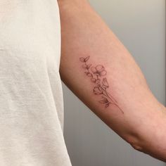 a woman's arm with a flower tattoo on the left side of her arm