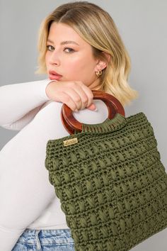 a woman is holding a green handbag