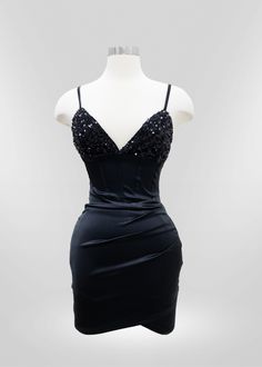 a mannequin wearing a black dress with sequins on the bust and shoulders