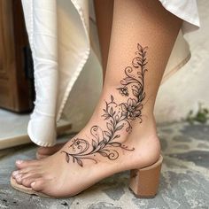 a woman's foot with a flower tattoo on it