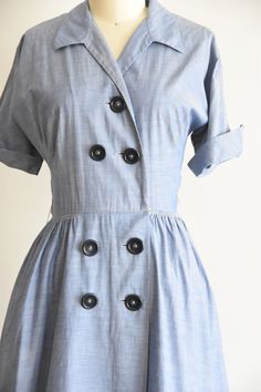 "Vintage early 1950s daydress. Chambray cotton, pointed collar, fold over sleeves, triple darted bust and nipped waist. Hidden side pockets. Free skirt. Loops for belt, missing belt. Front button closure. State of garment | very good, light overall wear and one itty hole on bodice and faint spot on skirt and collar. Measurements ✂--- Best fit | Small Bust | up to 38/39\" Shoulders | not specified Shoulder to waist | 16\" Sleeves | aprox 9\" Waist | 25\" Hips | free Total length (shoulder to hem) 1950s Collared Dresses With Buttons, Formal Cotton Dresses With Pockets, Vintage Cotton Dress With Buttons, Classic Vintage Dress With Button Closure For Daywear, Vintage Semi-formal Dresses With Button Closure, Cotton Vintage Dress With Buttons, Semi-formal Vintage Dresses With Button Closure, Vintage Button-up Dress With Button Cuffs, 1950s Collared Daywear Dresses