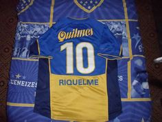 a blue and yellow soccer jersey with the number 10 on it sitting on a bed