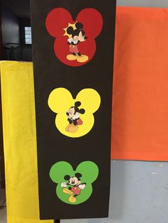 three mickey mouse stickers on a black board