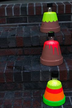 three different colored cones sitting next to each other on the steps in front of a brick building