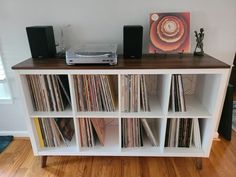 an entertainment center with record players and vinyls on the shelves in front of it