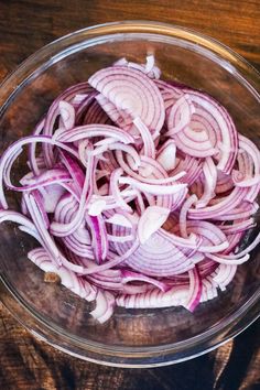 sliced onions in a glass bowl on a wooden table