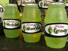 three green plastic water bottles sitting on top of a counter