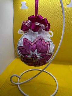 an ornament shaped like a flower on a yellow chair with a white cord