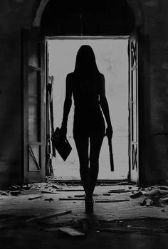 the silhouette of a woman walking into an open door