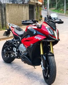 a red and black motorcycle parked on the street