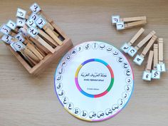 a plate with matchsticks on it next to some sort of magnets that spell out letters