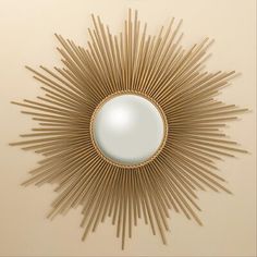 a gold sunburst mirror mounted on the wall