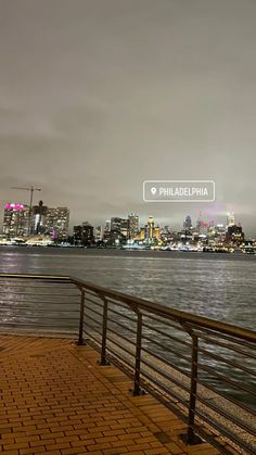 the city skyline is lit up in pink and purple as it sits next to the water