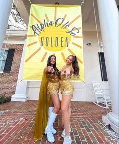 two women dressed in gold posing for the camera with a banner behind them that says banana queen golden