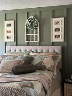 a bed sitting in a bedroom next to two pictures hanging on the wall above it