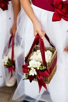 the bridesmaids are carrying baskets with flowers in them