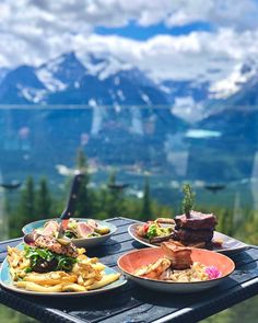 plates of food on a table with mountains in the background