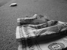 a rolled up dollar bill laying on the ground