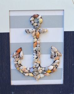 an anchor made out of seashells is displayed in a black and white frame