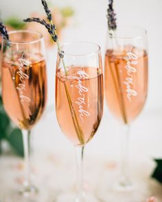 three wine glasses filled with champagne and lavender sprigs