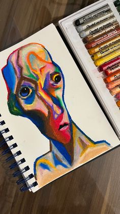 a drawing of a man's face with colored crayons next to it