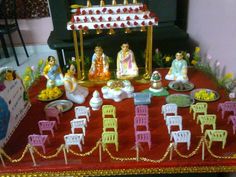 an elaborately decorated table with miniature chairs and figurines in front of a piano