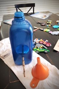 a blue water bottle sitting on top of a table next to an orange funnell