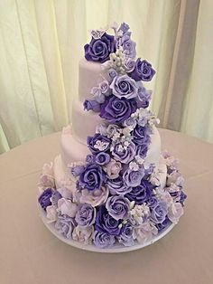 a three tiered cake with purple flowers on top