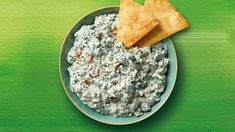 a bowl filled with spinach dip and crackers