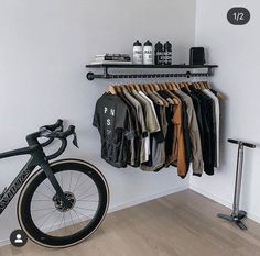 a bicycle is parked in front of a rack with shirts on it and clothes hanging up