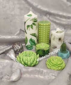 various candles and succulents on a silver cloth