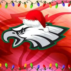 an eagle with a santa hat on it's head is surrounded by christmas lights