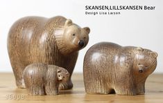 two wooden bears are standing next to each other on a table with the caption skaansen lilskanen bear