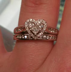 a close up of a person's hand with two wedding rings