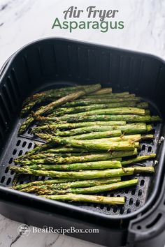 the asparagus are being cooked in an air fryer with text overlay that reads, air fryer asparagus