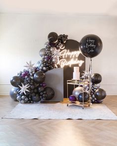 a birthday party with balloons and decorations on the floor in front of a sign that says happy birthday