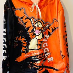 This Is The Cutest Tigger Hoodie From Walt Disney World. Nwot And Lots Of Personality Just Like Tigger. Graphic Designs Are On The Front And Back As Well As On The Sleeves, Which Are Black And Orange And Say Tigger Was Well Has Incorporating The Tigger Graphic. The Jacket Is A Size Large And Has Front Measurements Of: Bust -25.5 Inches At The Arm Pit; Sleeves Are 23" And The Length Is 29". Great For A Man, Woman Or Teen. Disney Hooded Sweatshirt With Cartoon Print, Disney Cartoon Print Hooded Sweatshirt, Black Disney Sweatshirt For Streetwear, Casual Hooded Sweatshirt For Disney Fan Events, Disney Sweatshirt For Fall Streetwear, Disney Long Sleeve Hoodie For Fan Events, Star Wars Jacket, Mens Navy Jacket, Half Zip Windbreaker