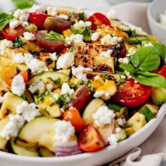 a white bowl filled with vegetables and feta cheese