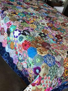 a bed with a colorful quilt on top of it