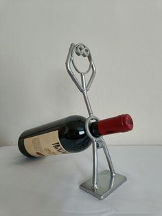 a wine bottle holder made to look like a person holding a corkscrew with both hands