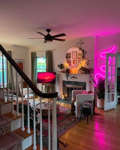 a living room filled with furniture and a fire place under a ceiling fan next to a fireplace