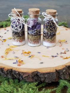 three glass bottles filled with different types of herbs