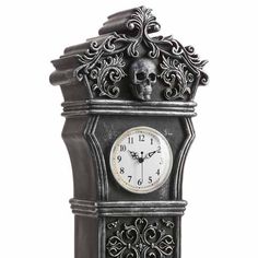 an ornate clock with a skull on the front and sides, is shown against a white background