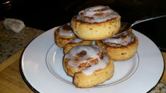 some cinnamon rolls on a white plate with a spoon