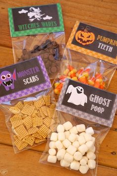 halloween treat bags filled with candy and candies on top of a wooden table next to other treats