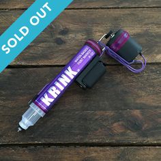 a purple and black water bottle sitting on top of a wooden table