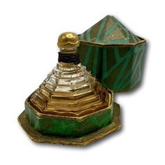 a green and gold vase sitting on top of a table