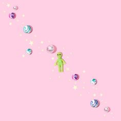 an alien is standing in the middle of space surrounded by planets and stars on a pink background