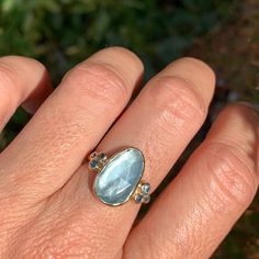 A baby blue Aquamarine is Set in 14k yellow gold with a pair of deep blue and teal sapphires and vibrant blue zircons. Emily's handmade seagrass band finishes this stunning piece. Approx stone size: 15 mm x 9mm Approx stone weight: 4.1cts Mohs Hardness: 7.5-8 This one of a kind piece is handmade to order in Emily's Hudson Valley studio. If you have questions about sizing, shipping or need help deciding please reach out to us! Alternative Engagement Ring, Aquamarine Ring, Local Jewelry, Alternative Engagement Rings, Aquamarine Rings, Blue Zircon, Aquamarine Blue, Vibrant Blue, Diamond Cluster